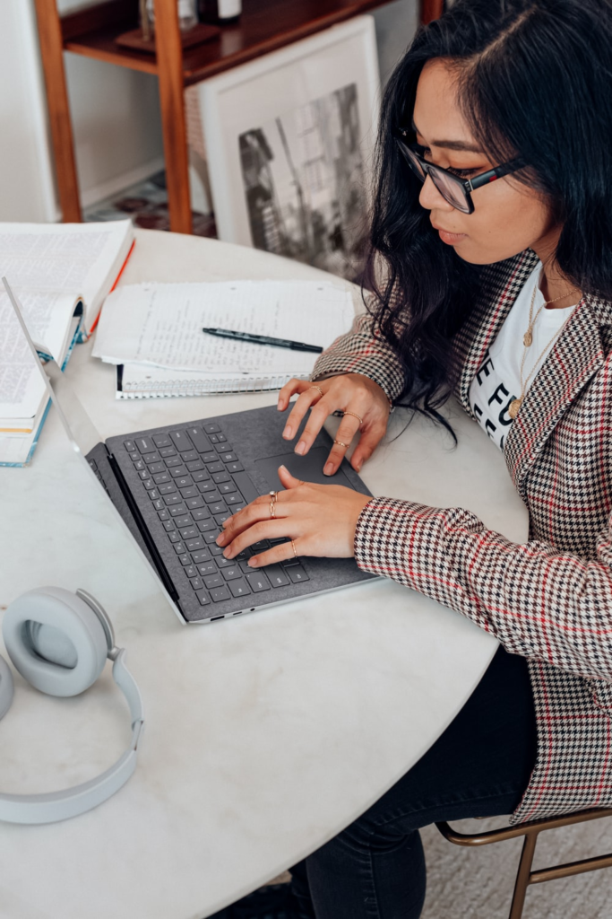 A professional genealogist conducting research using a laptop and notes