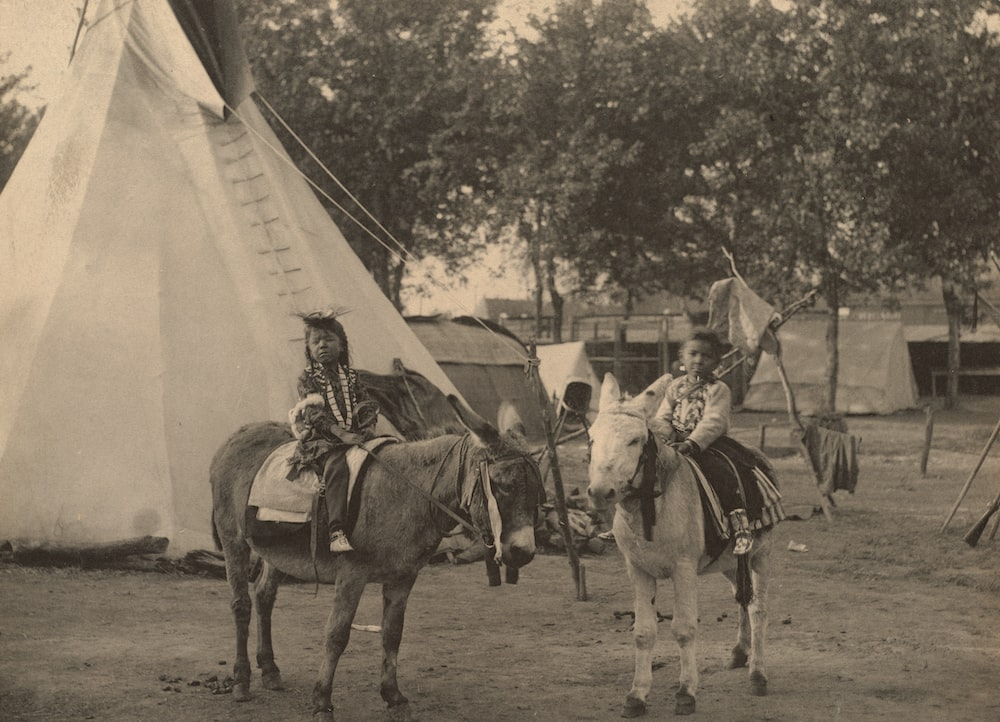  A grey-scale photograph of Native American children on horses 