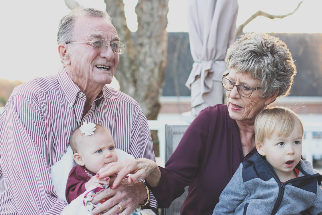 grandparents holding their grandchildren.