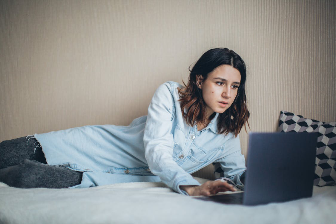 a woman using her laptop in bed.