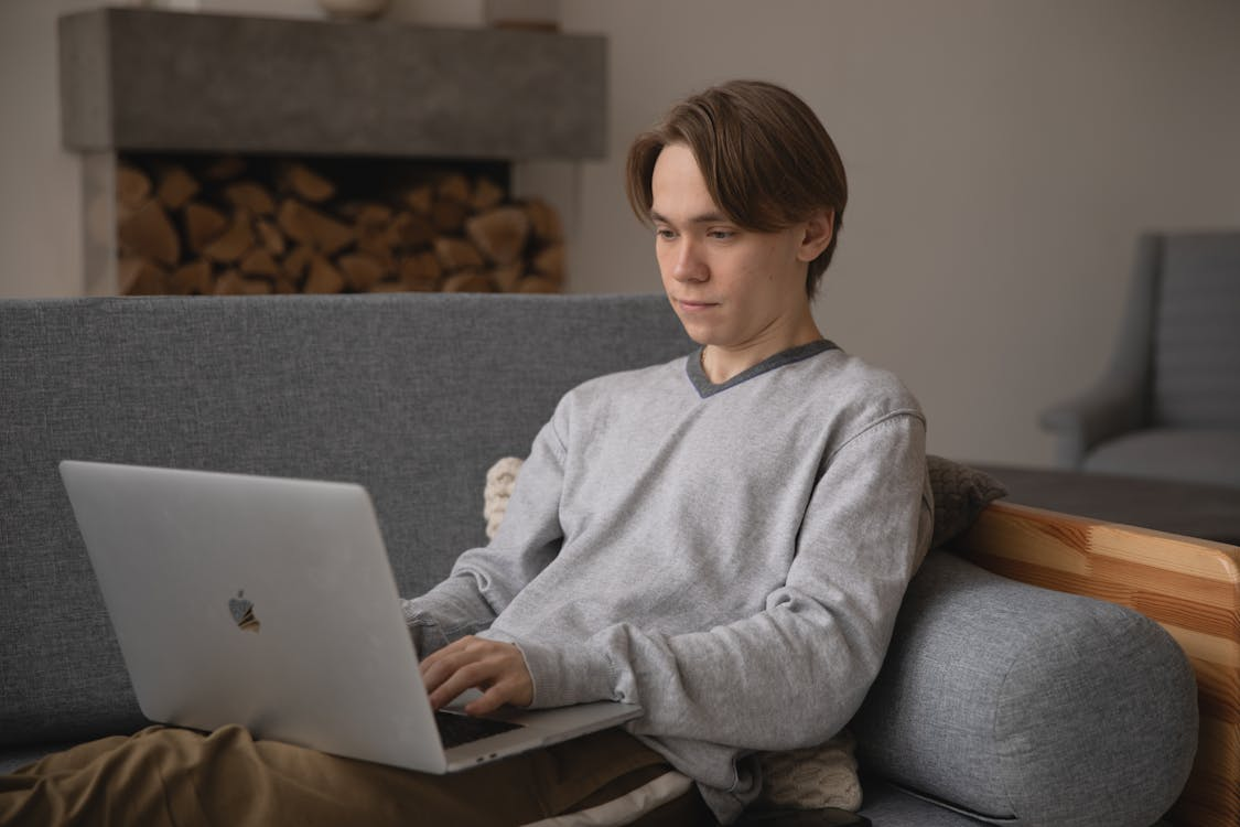 a man sitting on a gray couch.