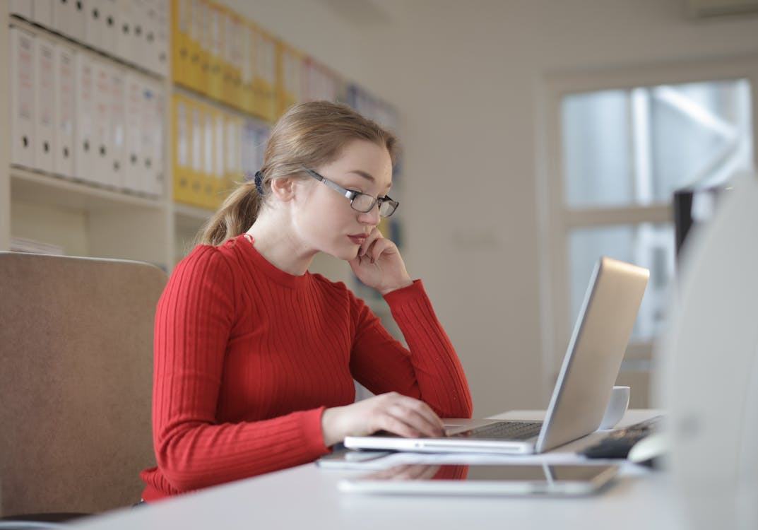  a woman in a red top sitting at work.