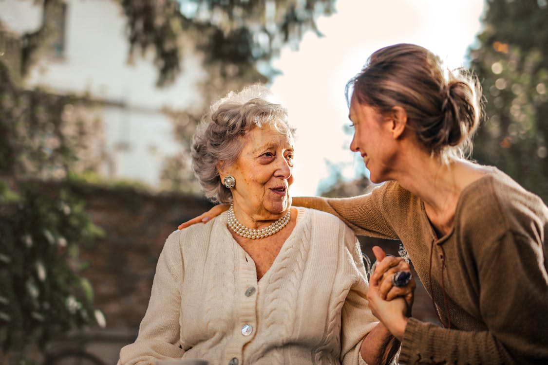 two women talking outdoors.